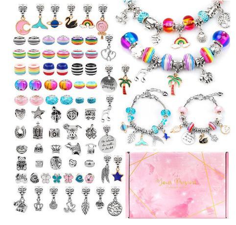 Beads, dangling charms, and finished bracelets arranged beside a pink storage box
