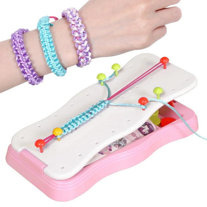 Braided bracelets on a wrist beside the pink bracelet-making frame