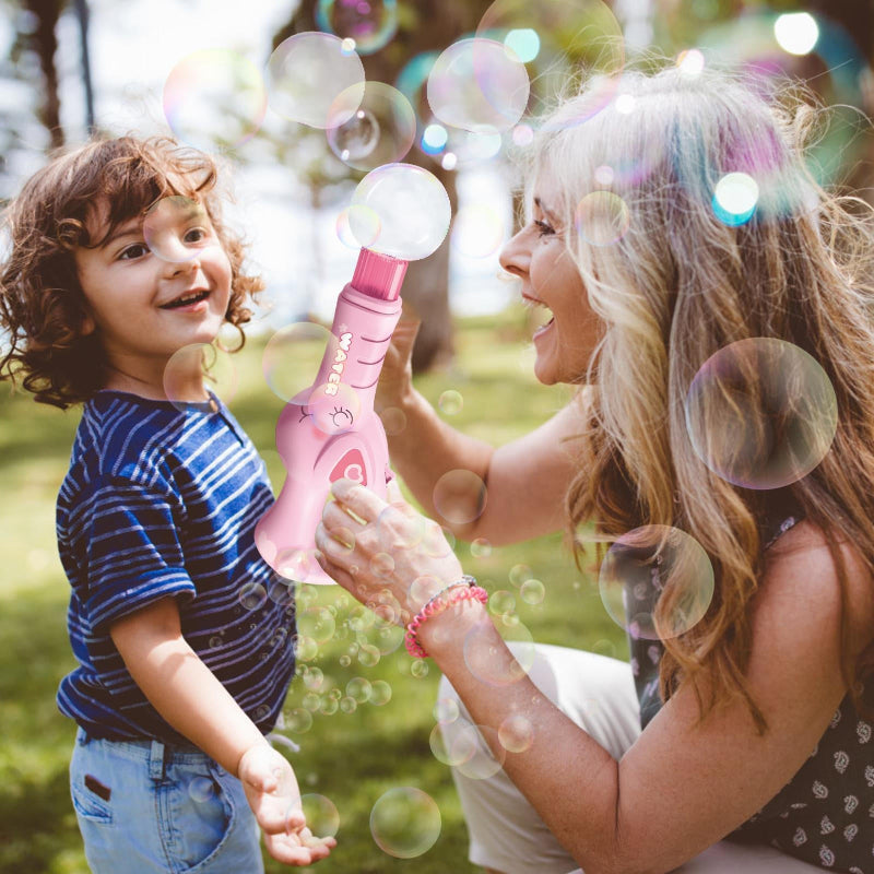 Adult and child watching bubbles from a pink electric bubble maker outdoors