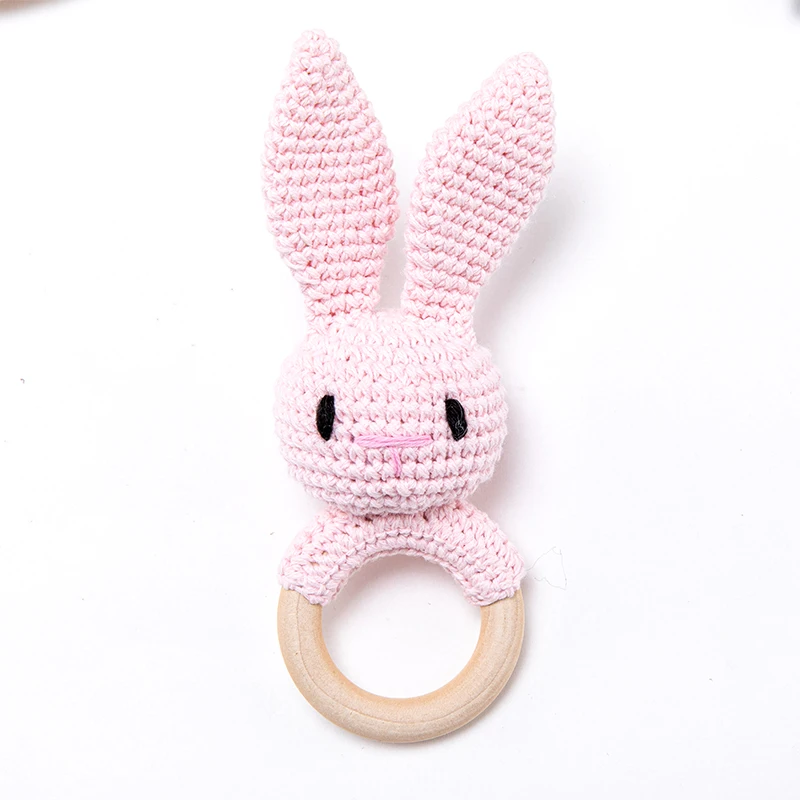 Pink crocheted bunny rattle with long ears and a natural wooden ring