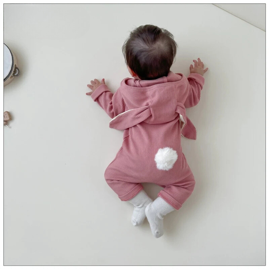 Back view of the pink baby romper with floppy bunny ears and a white pom-pom tail