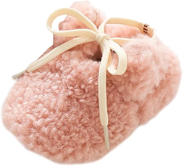 Close-up of pink plush bunny slippers with a cream bow and small ears