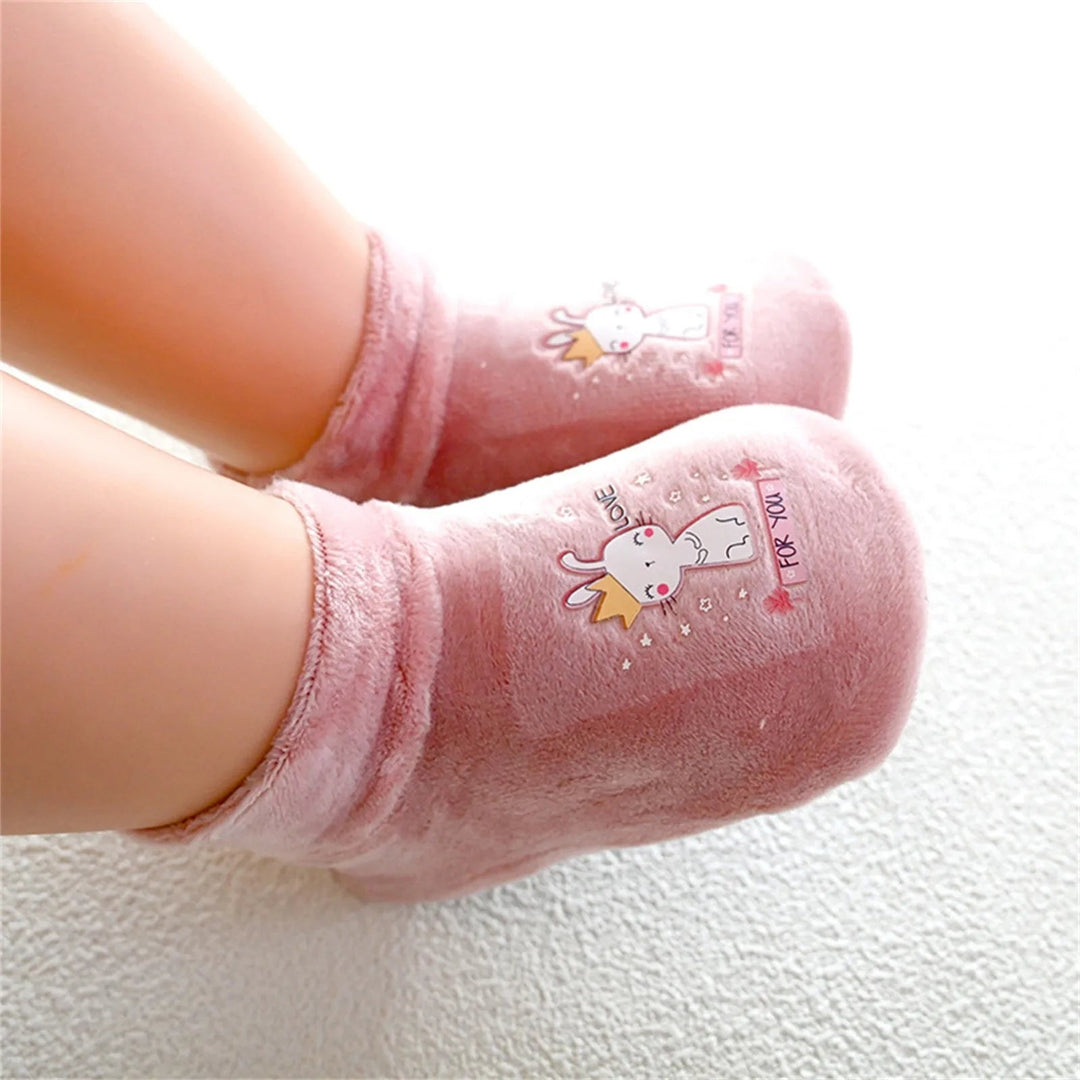 Pink bunny-print sock shoes worn on a child's feet