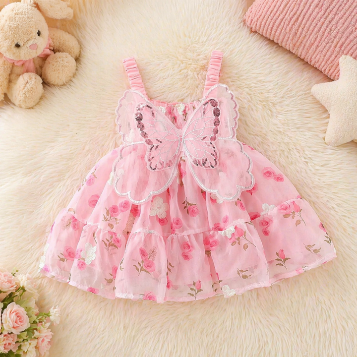 Pink butterfly baby dress laid flat, showing the floral skirt and back wings