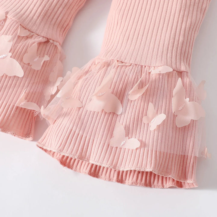 Flared pink pant cuffs with sheer overlays and butterfly accents