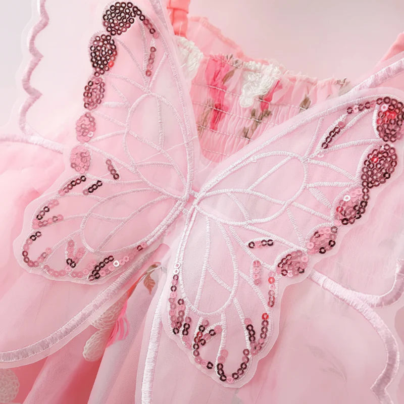 Close-up of sheer pink butterfly wings with embroidered lines and sequin accents