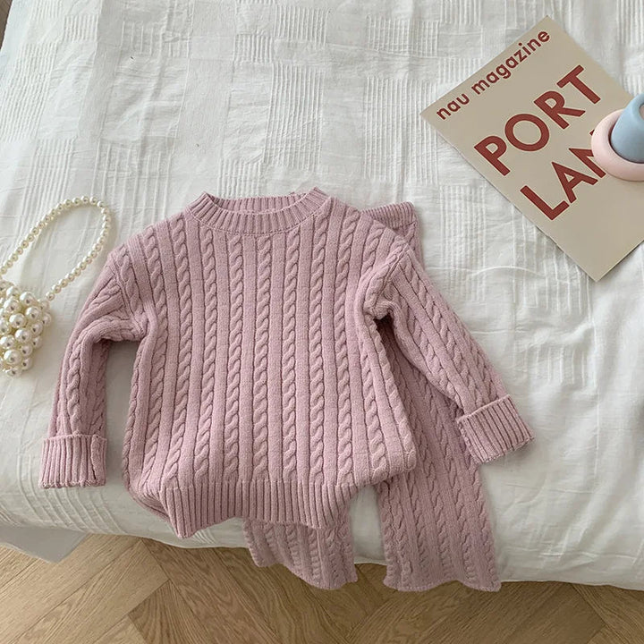 Pink cable-knit sweater with ribbed cuffs and matching pants