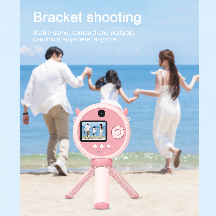 Pink camera on an open tripod, pictured with a family at the beach