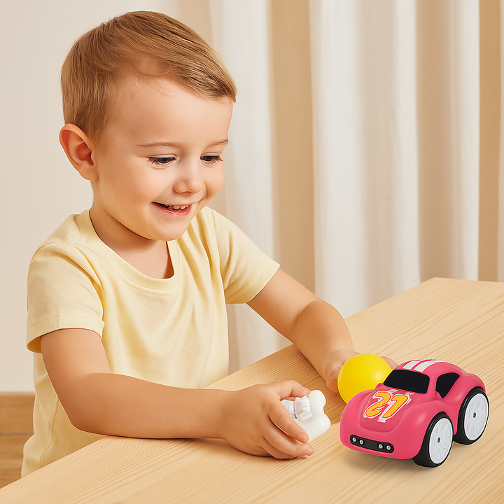 Child playing at a table with a pink cartoon car and white remote control