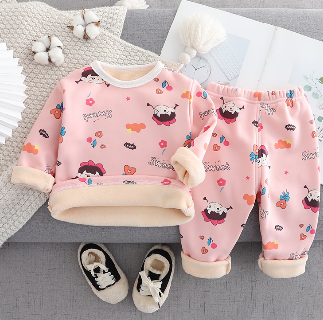 Pink fleece pajama set with colorful cartoon prints and cream collar, cuffs, and hem