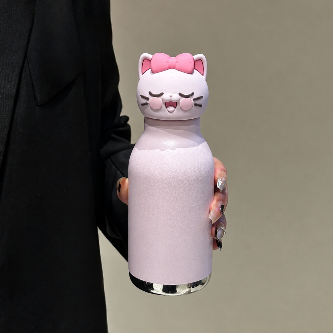 Pink cat thermos bottle with a cat-face cap and bow, held in one hand