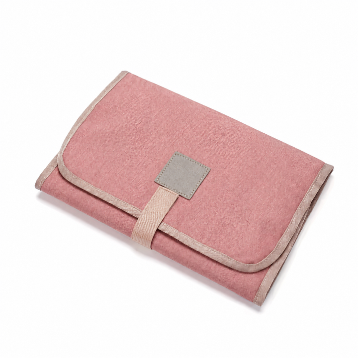 Pink changing mat folded with a square patch and beige edging