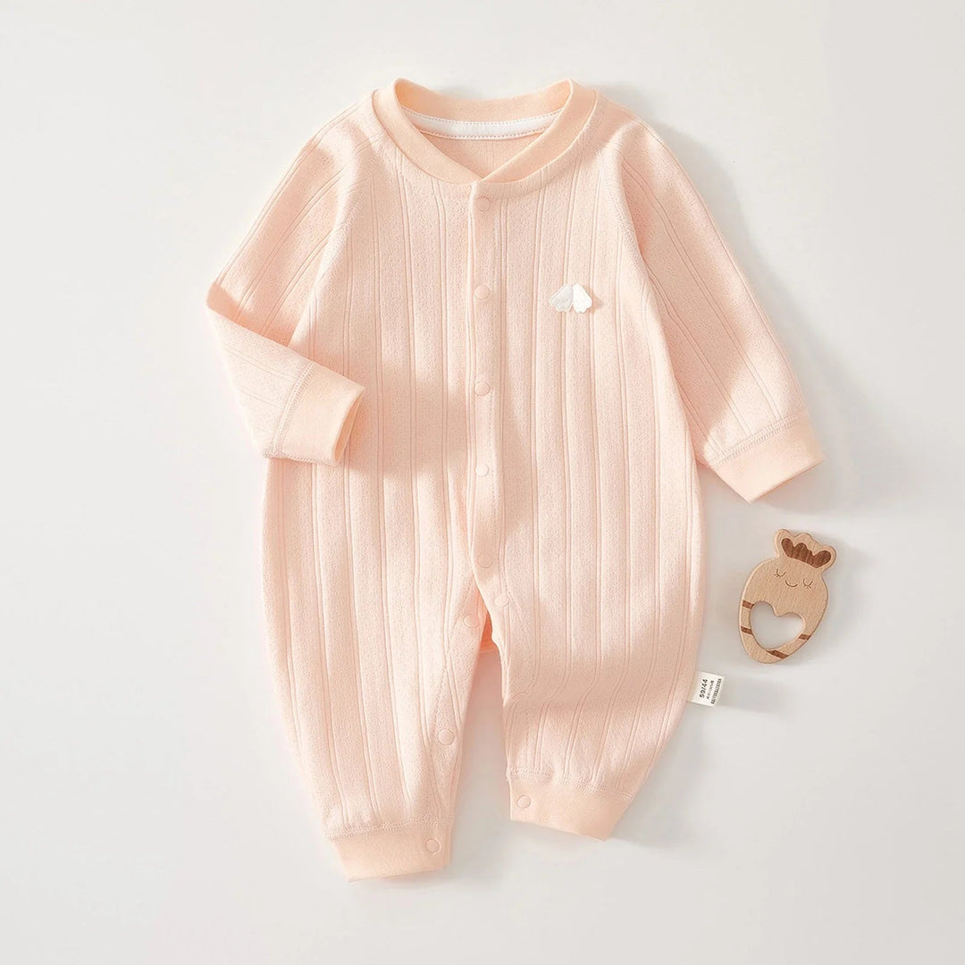 Pink long-sleeve cotton baby romper laid flat with one sleeve folded