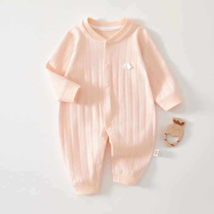 Pink long-sleeve cotton baby romper laid flat with one sleeve folded