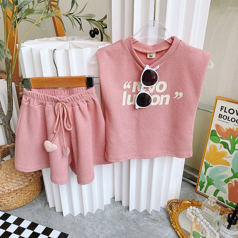 Pink girls' outfit showing the sleeveless printed top and elastic-waist shorts