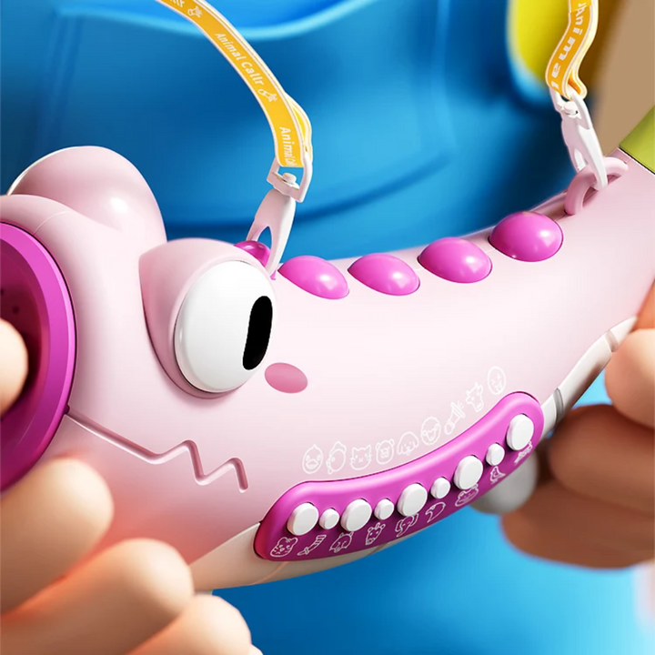 Close-up of a pink crocodile sound toy with top buttons, side controls and an attached strap