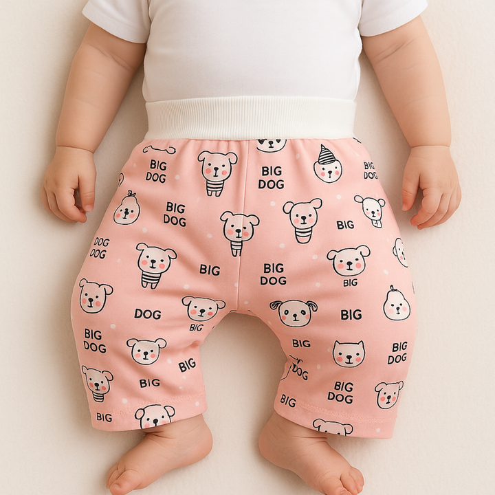 Baby wearing pink dog-print training pants with a wide white waistband