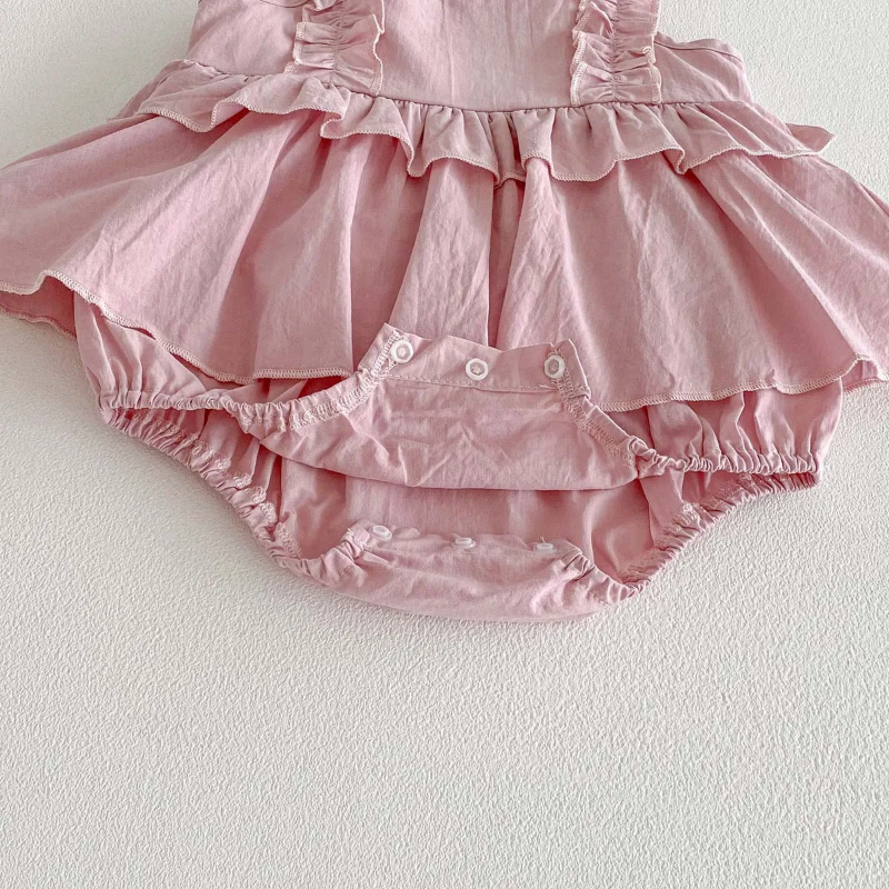 Pink baby dress romper with the bottom snaps open beneath the ruffled skirt
