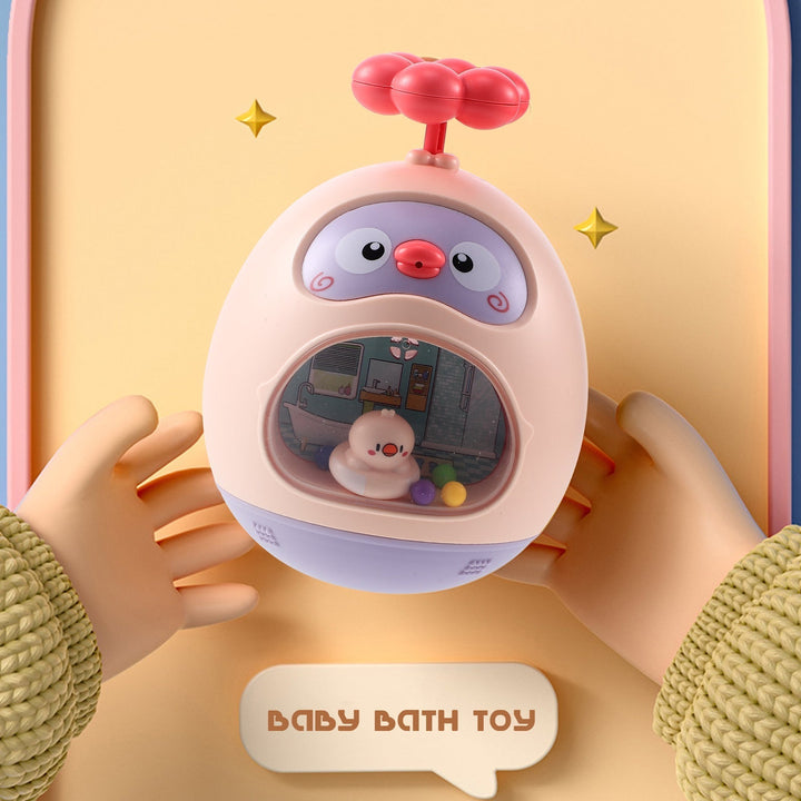 Hands holding a pink duck-shaped bath toy with a clear front window and flower-shaped handle