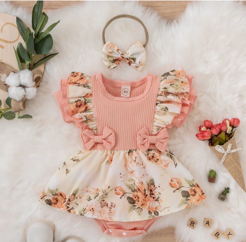 Pink baby romper with a ribbed top, floral ruffle sleeves and skirt, displayed with a bow headband