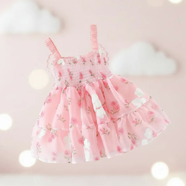 Front view of a pink floral baby dress with a smocked bodice and ruffled straps
