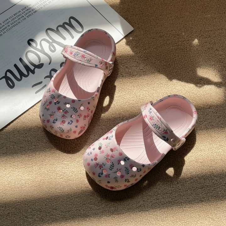 Pink floral sandals with ventilation holes and adjustable straps, shown at an angle