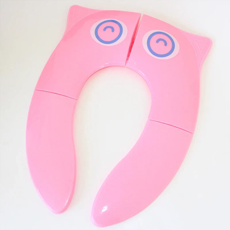 Pink folding toilet training seat with blue eye graphics
