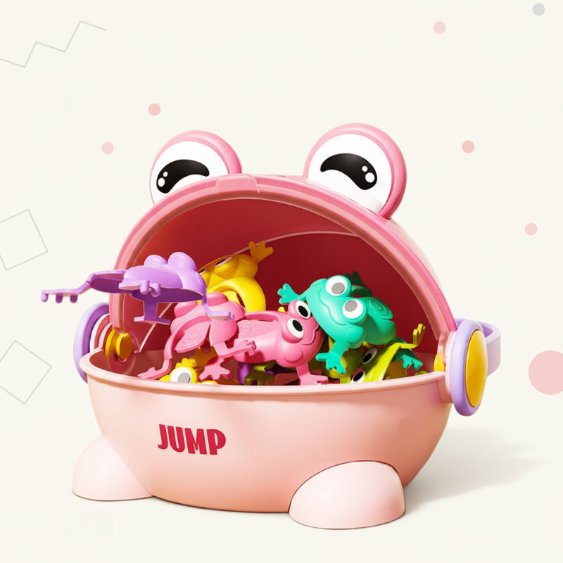 Pink frog-shaped game case with an open mouth holding small jumping frogs.