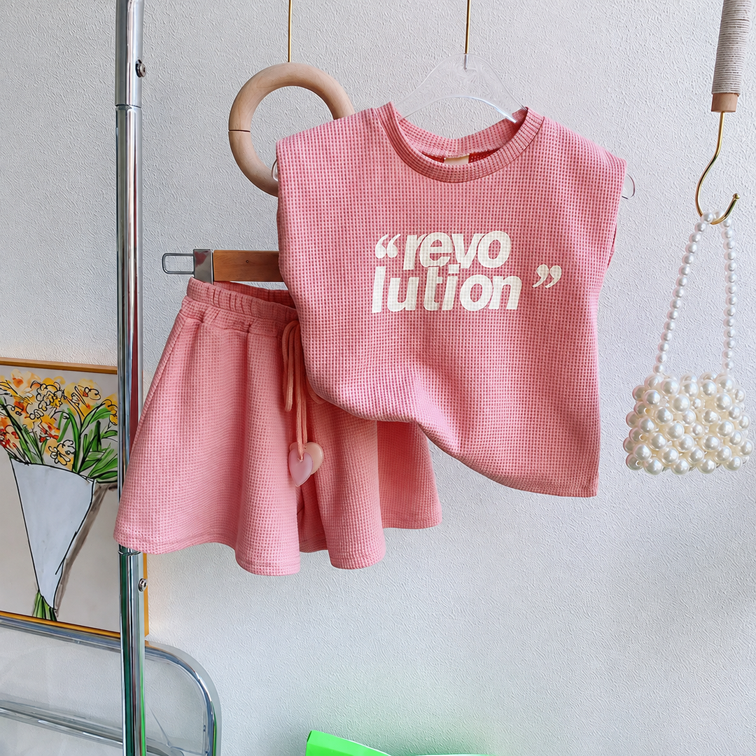 Pink girls' sleeveless top with white lettering and matching drawstring shorts hanging together