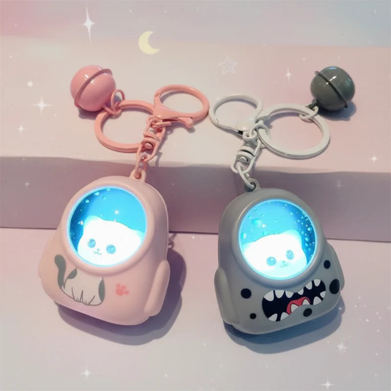 Pink and gray astronaut capsule charms with blue-lit helmets and matching bells
