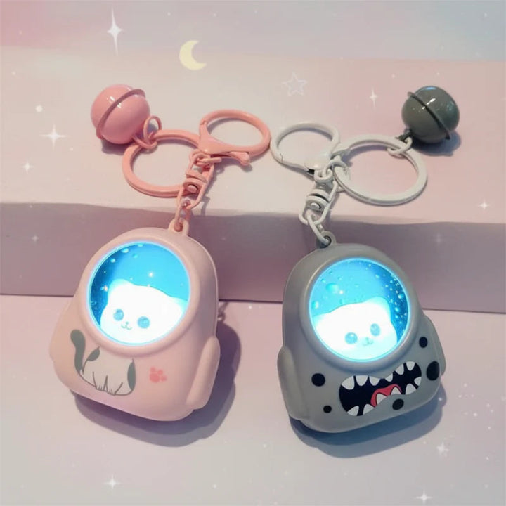 Pink and gray astronaut capsule charms with blue-lit helmets and matching bells