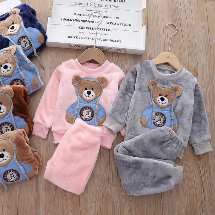 Pink and gray bear sweatshirts with matching pants, with other colors folded beside them