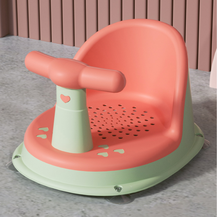 Pink and green baby bath seat with a green base and front bar post