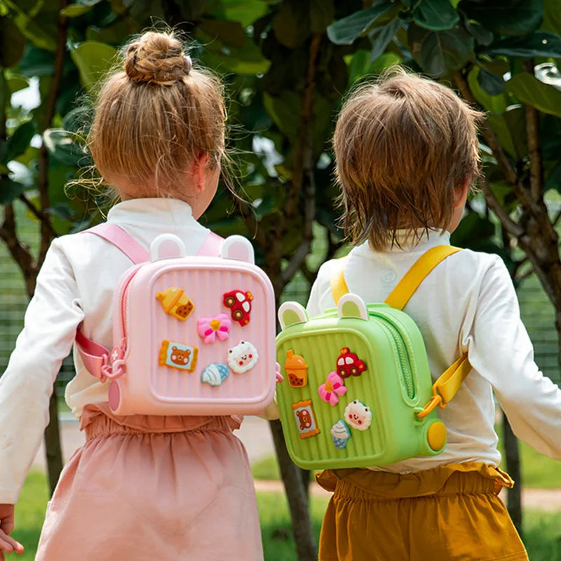 Two children wearing pink and green backpacks during an outdoor walk