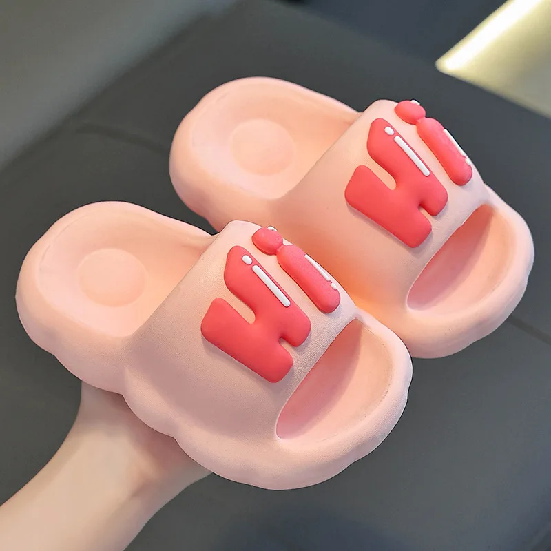 Pink slide slippers with raised coral Hi lettering.