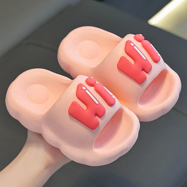 Pink slide slippers with raised coral Hi lettering.
