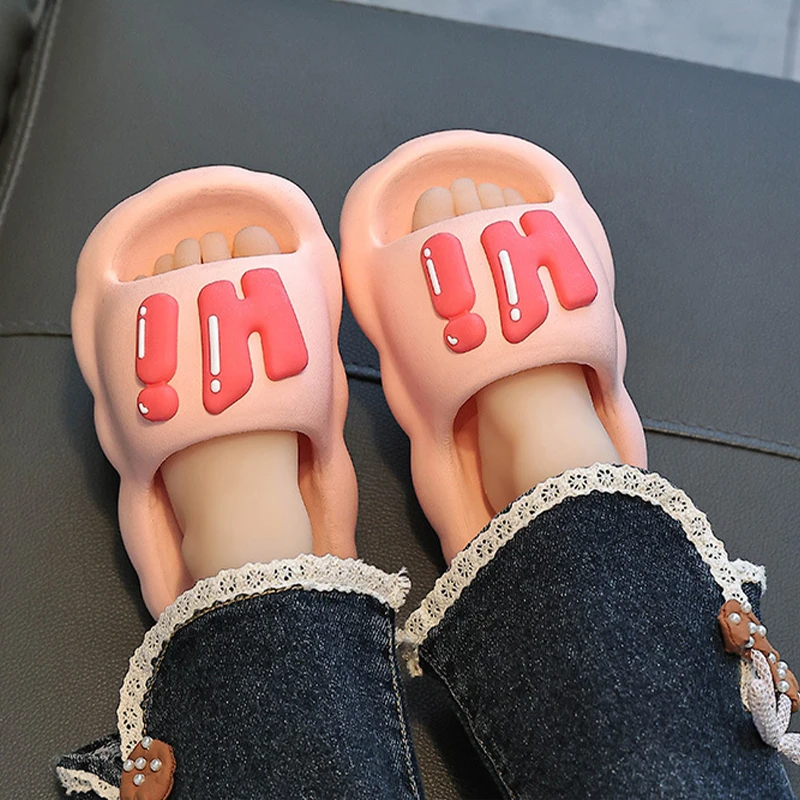 Pink Hi slide slippers worn with dark pants.