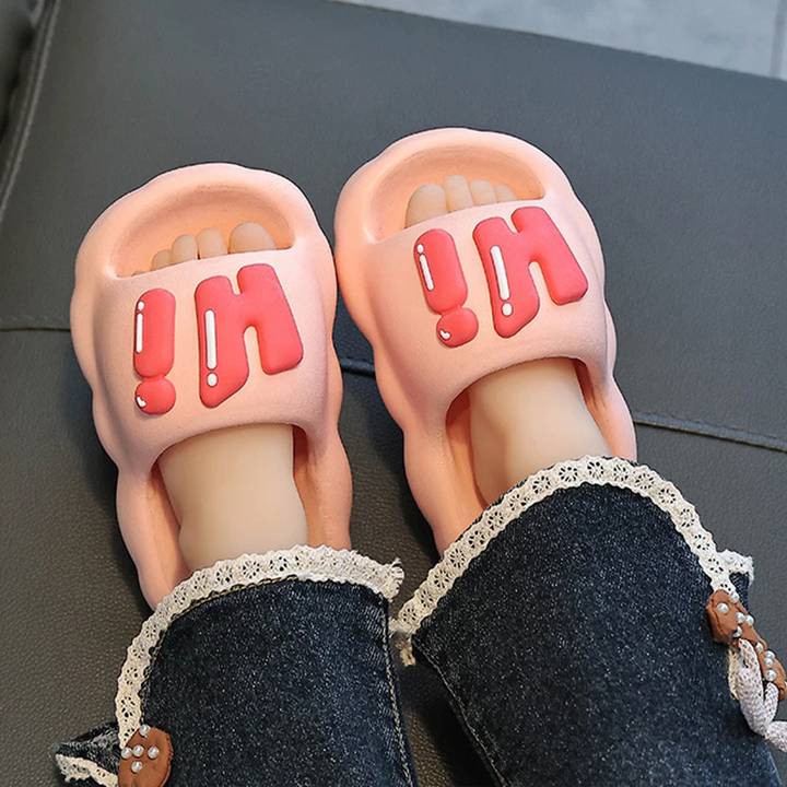 Pink Hi slide slippers worn with dark pants.