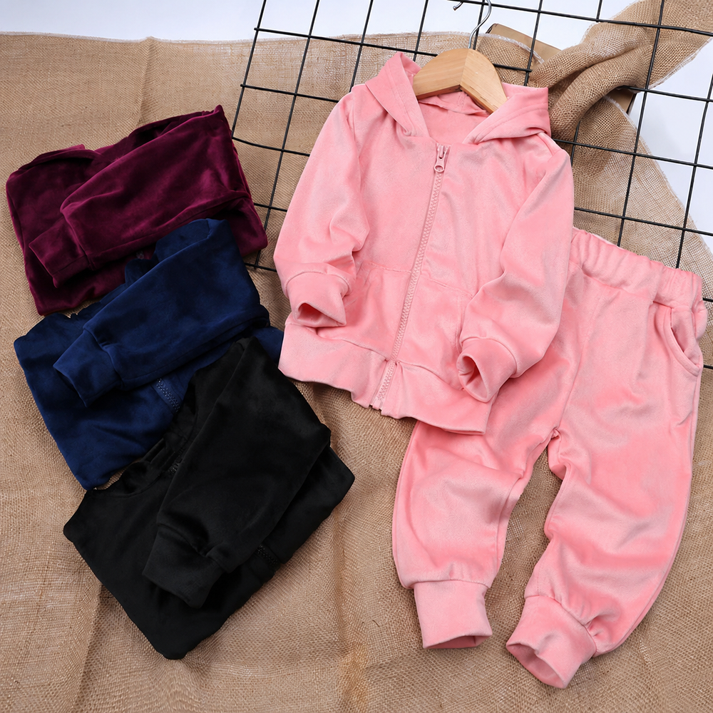 Pink zip-up hoodie and matching joggers beside folded plum, navy and black garments