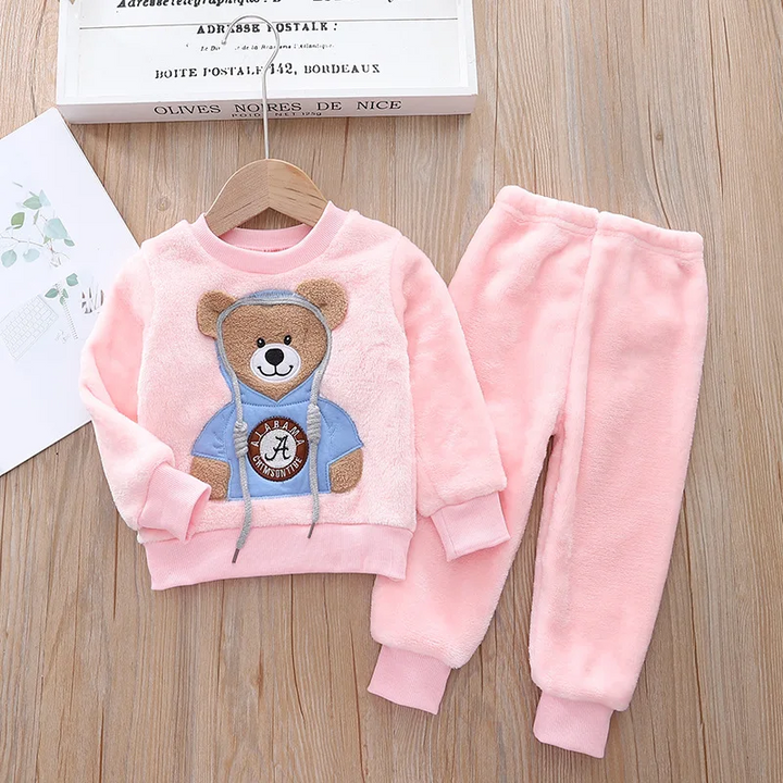 Pink bear sweatshirt and matching pants displayed on a wooden floor