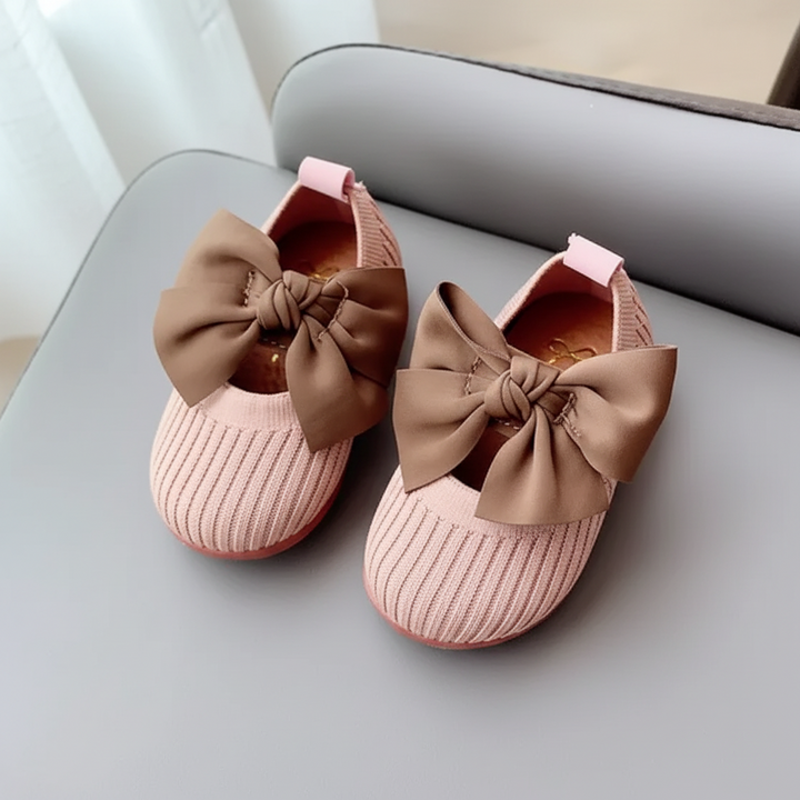 Pair of pink knitted baby shoes with brown bows and heel pull tabs