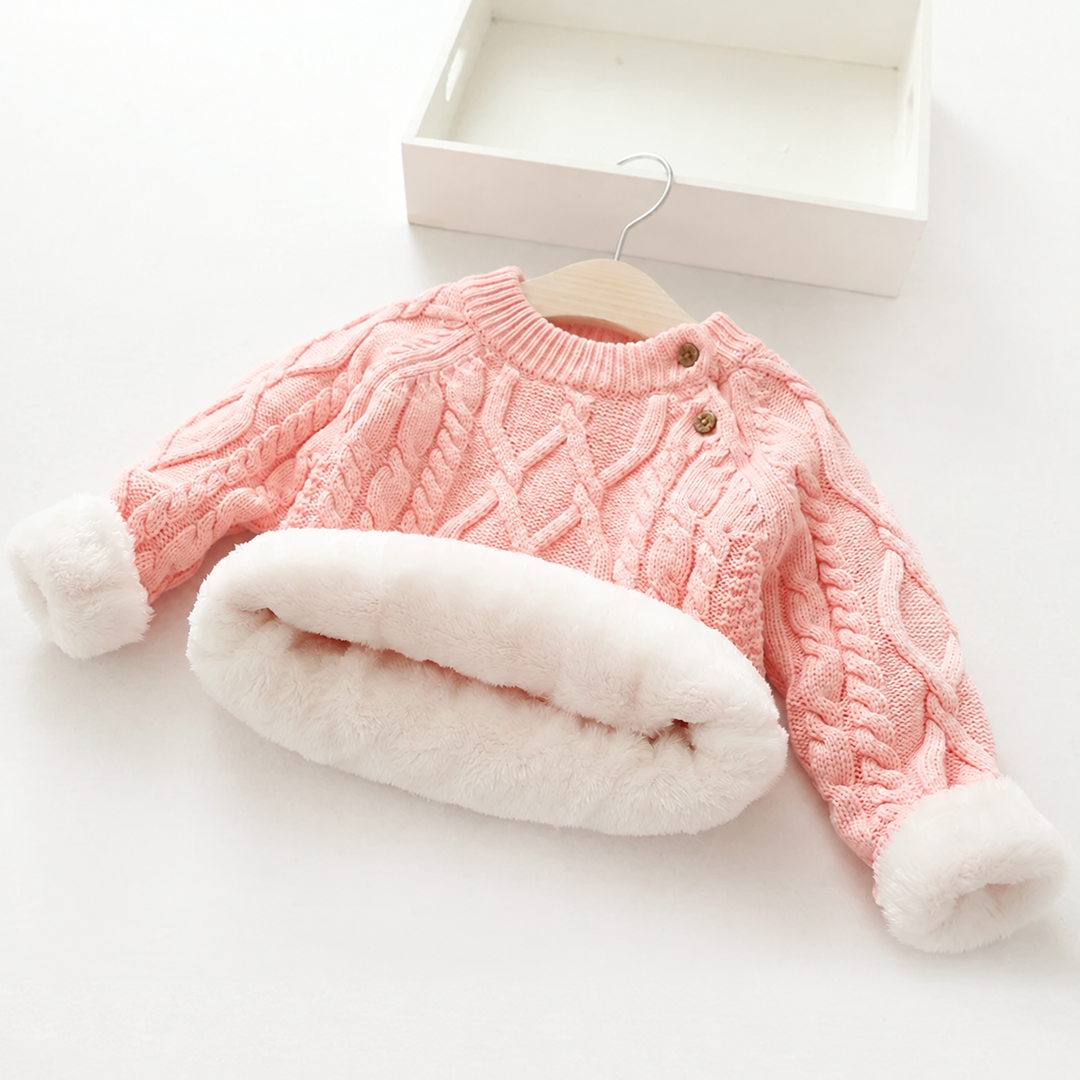 Pink cable-knit sweater with turned-back cuffs and hem showing plush white lining.
