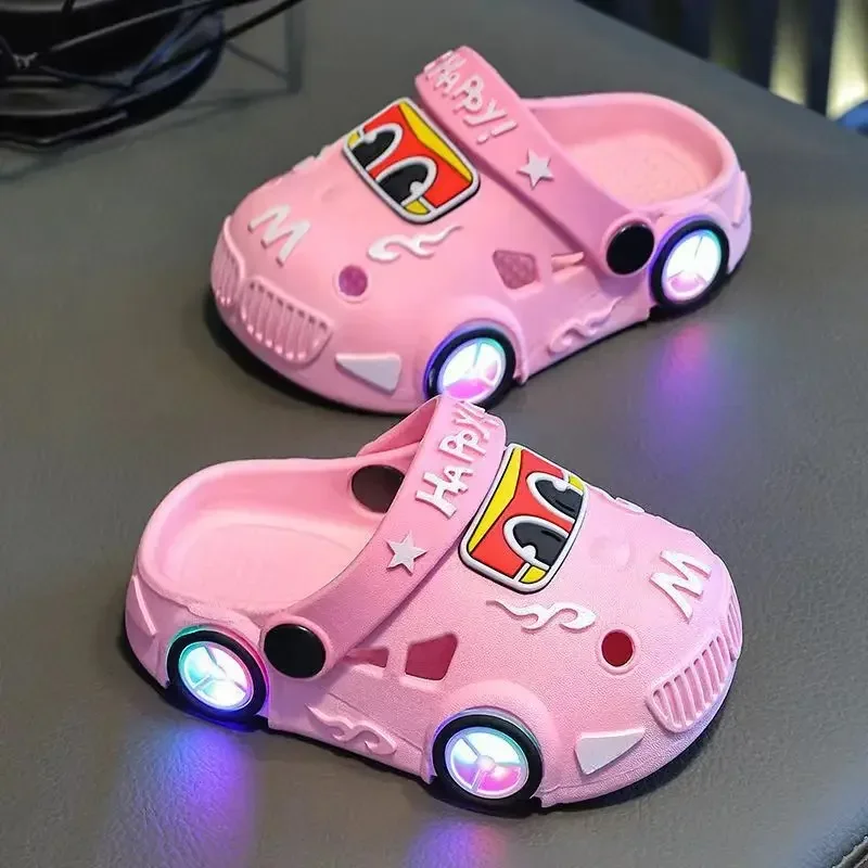 Pink car slippers with illuminated wheel details and ventilation openings.