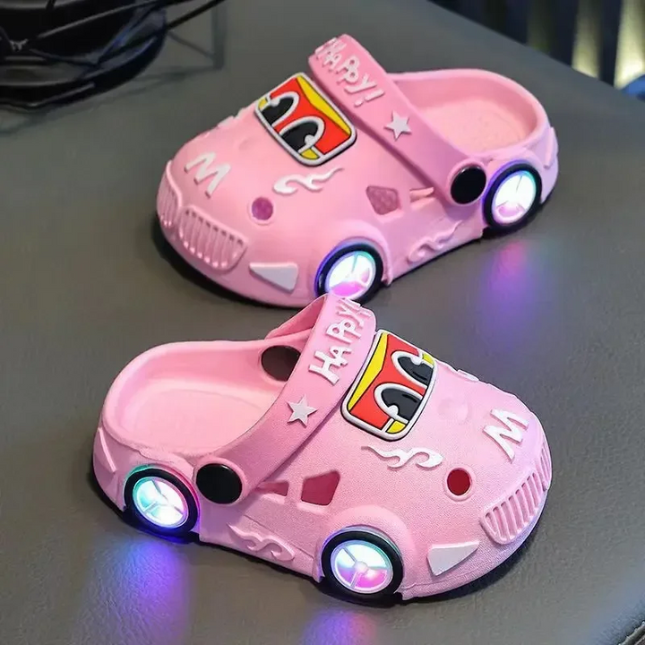 Pink car slippers with illuminated wheel details and ventilation openings.