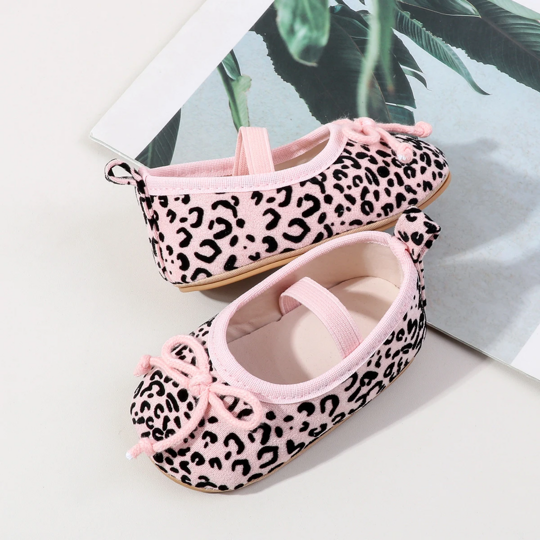 Pink leopard-print baby shoes with matching elastic straps and decorative front bows