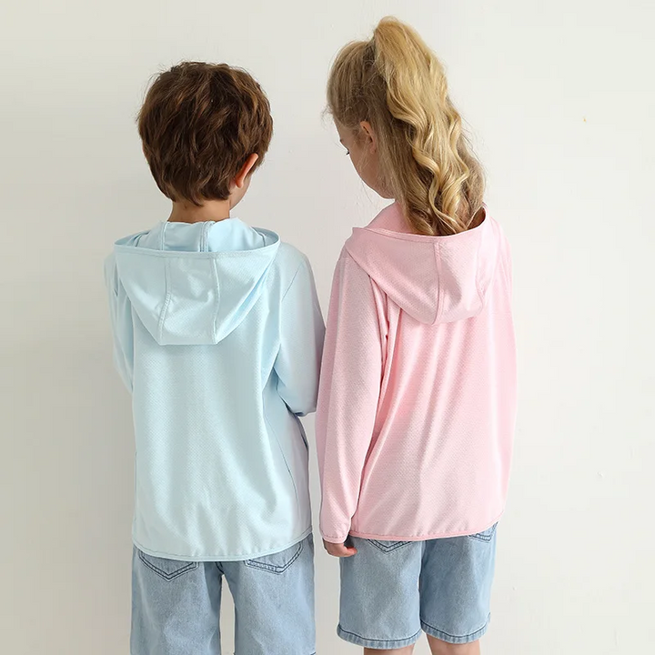 Back view of children wearing light blue and pink jackets with the hoods down.