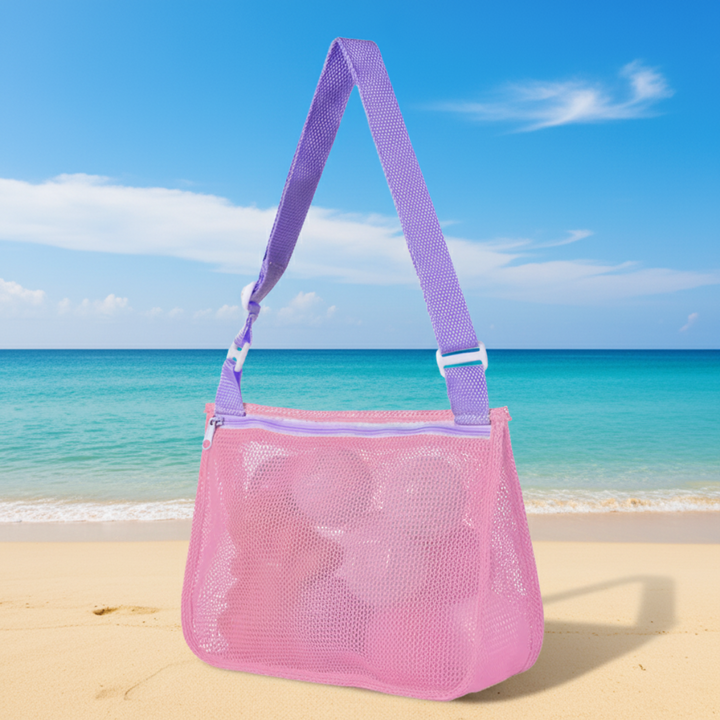 Pink mesh beach bag with a purple adjustable shoulder strap on the sand