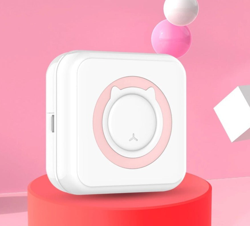 White mini photo printer with pink trim and a cat-shaped front detail