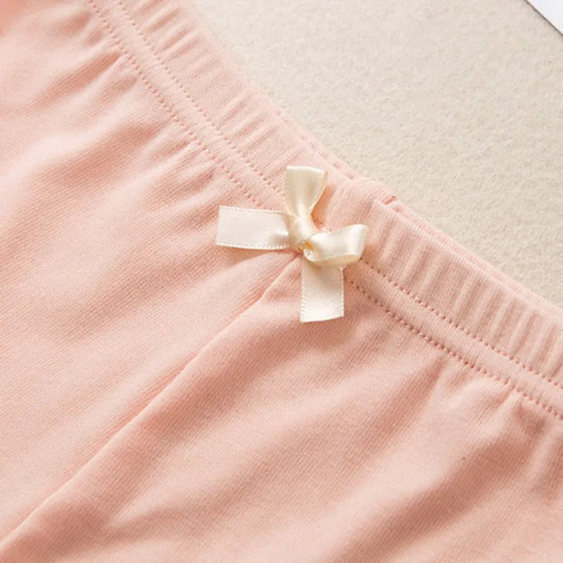 Close-up of the elastic waistband and cream bow on pink pajama shorts