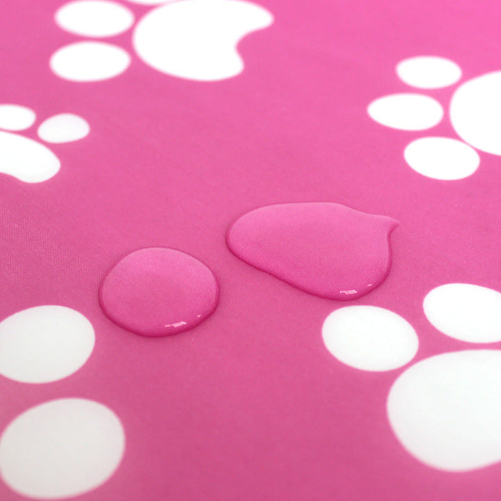 Water droplets on the pink paw-print play mat fabric.